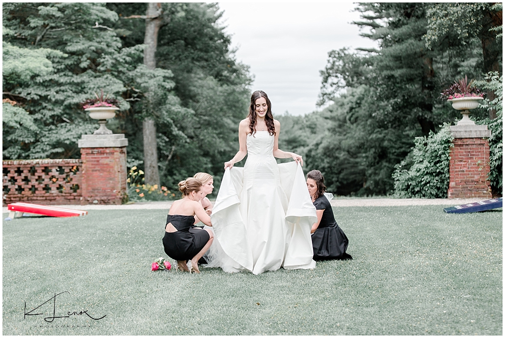 Candid photo of Bride getting her dress bustled at a  Bradley Estate Wedding- Canton Mass Photographer 