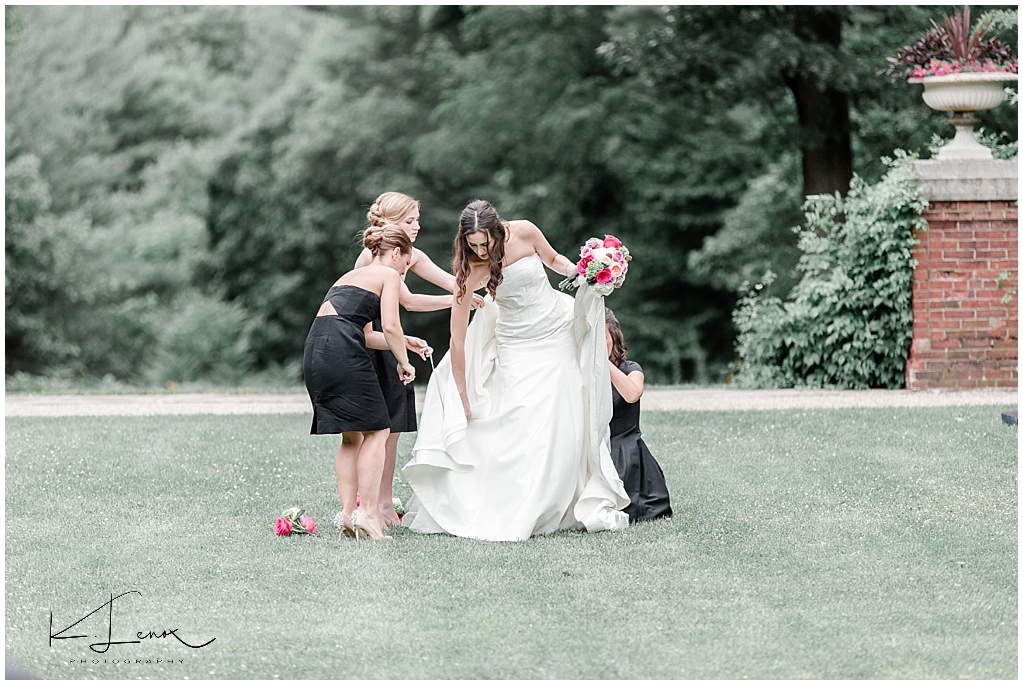 Candid and Authentic photo of Bride and her Bridesmaids bustling her gown at a Bradley Estate Wedding in Canton Ma