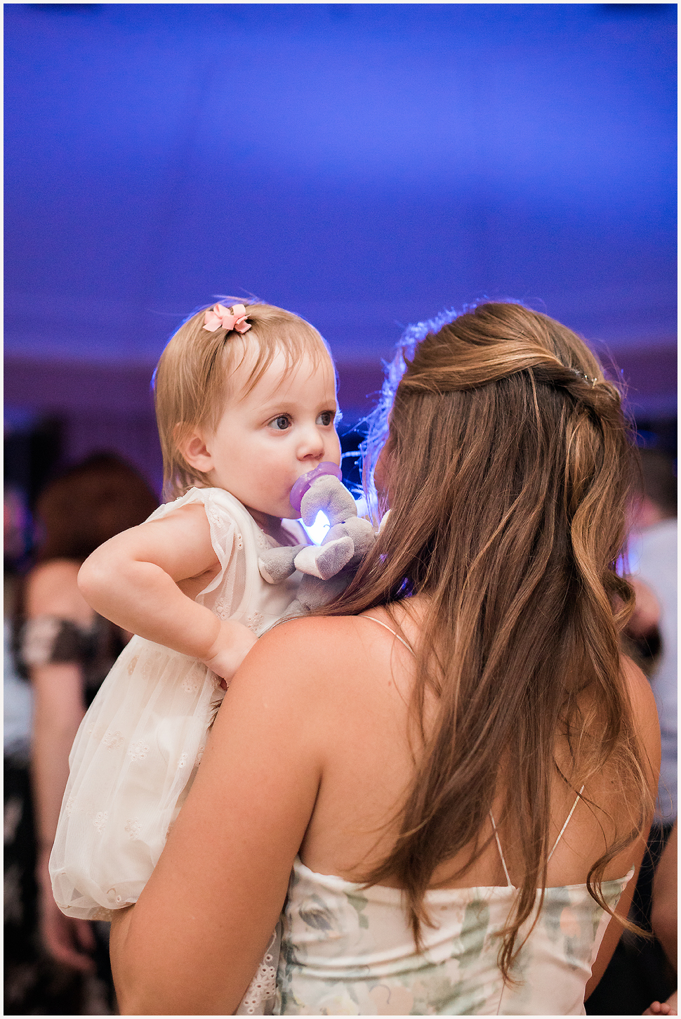 Toddler Flower girl being held by her mom during a wedding reception at the Equinox. 