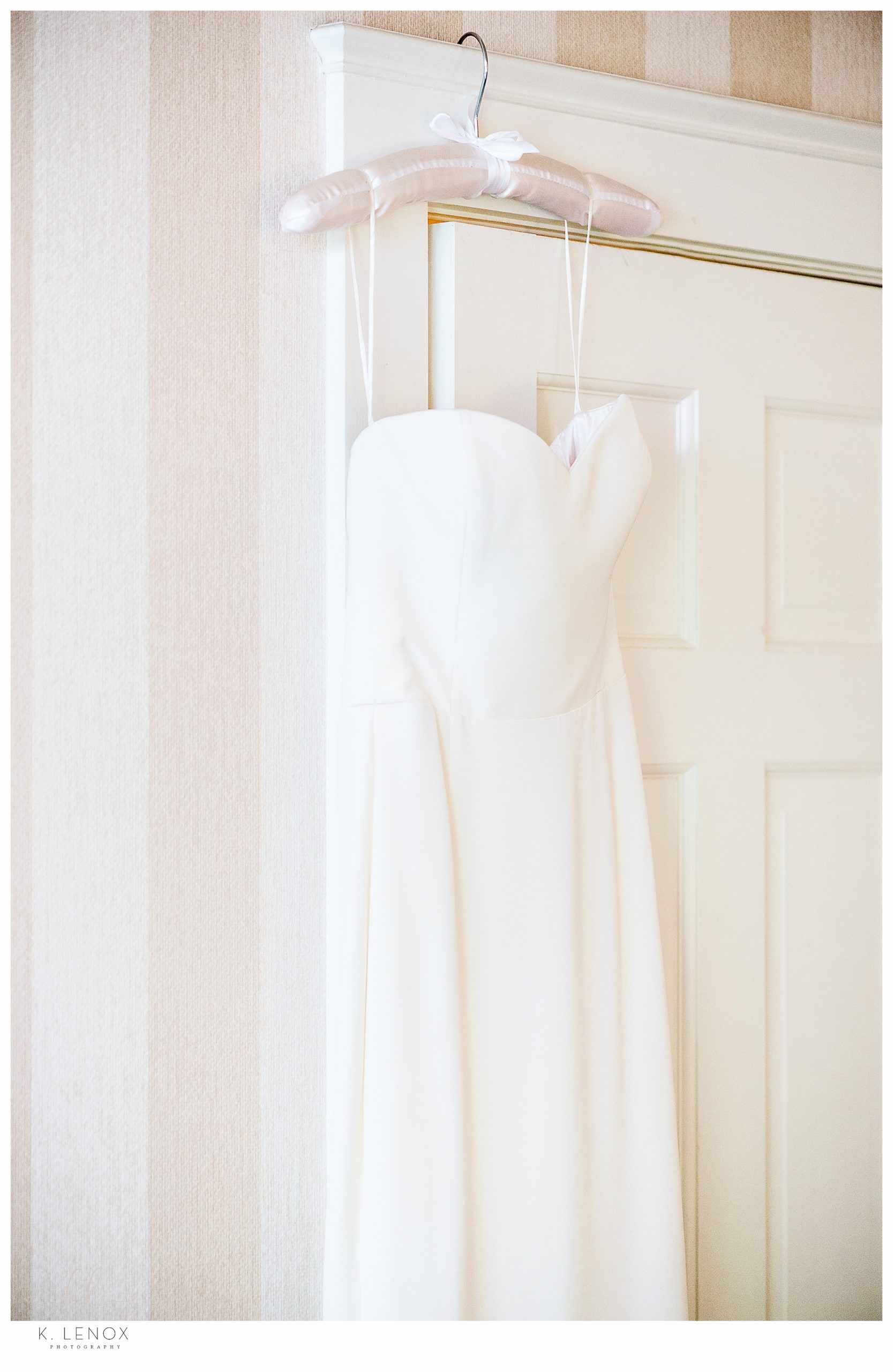 Elegant wedding dress hanging on a door at the Equinox