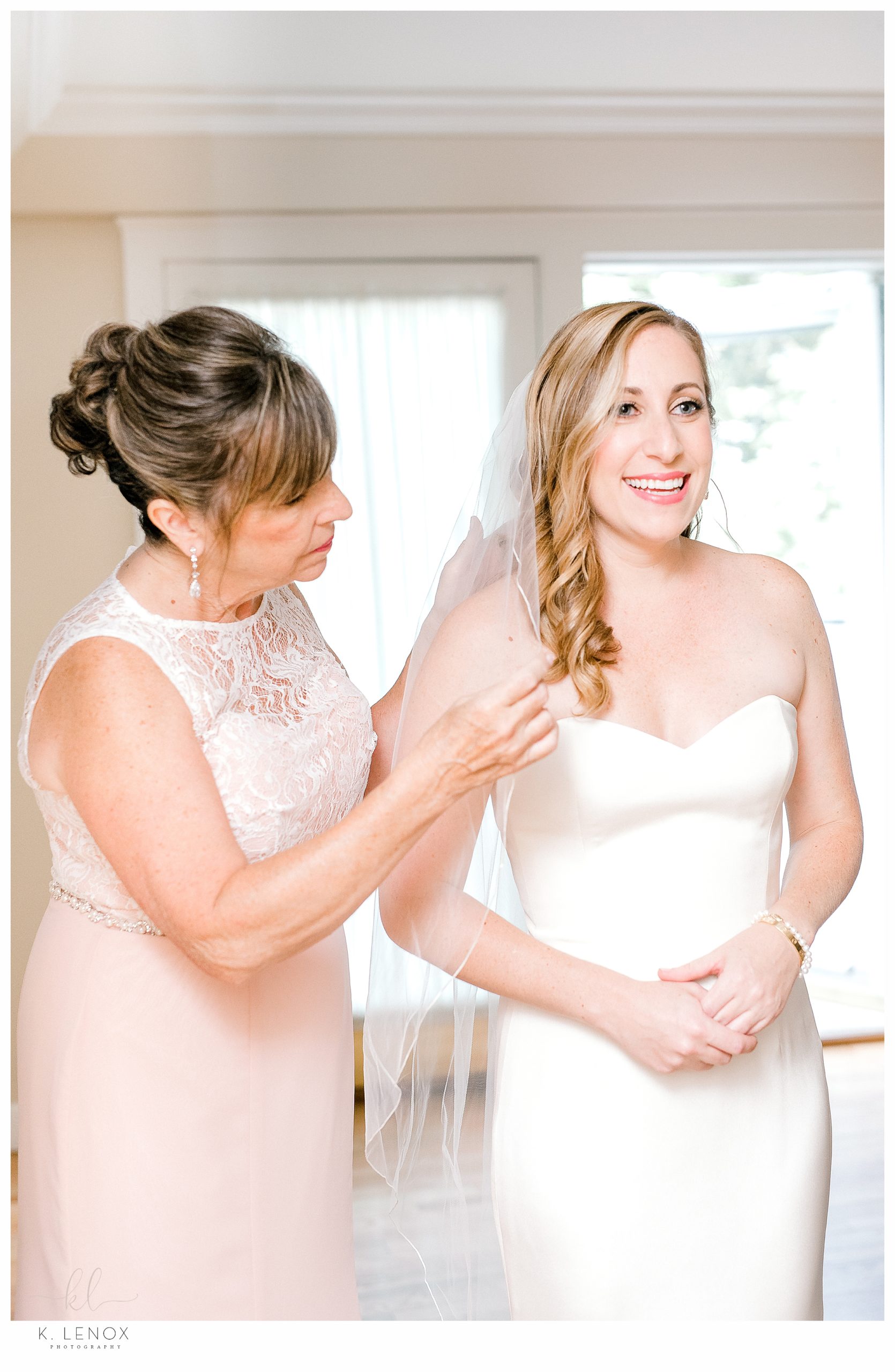 Mother of the bride assists bride with her Veil. 