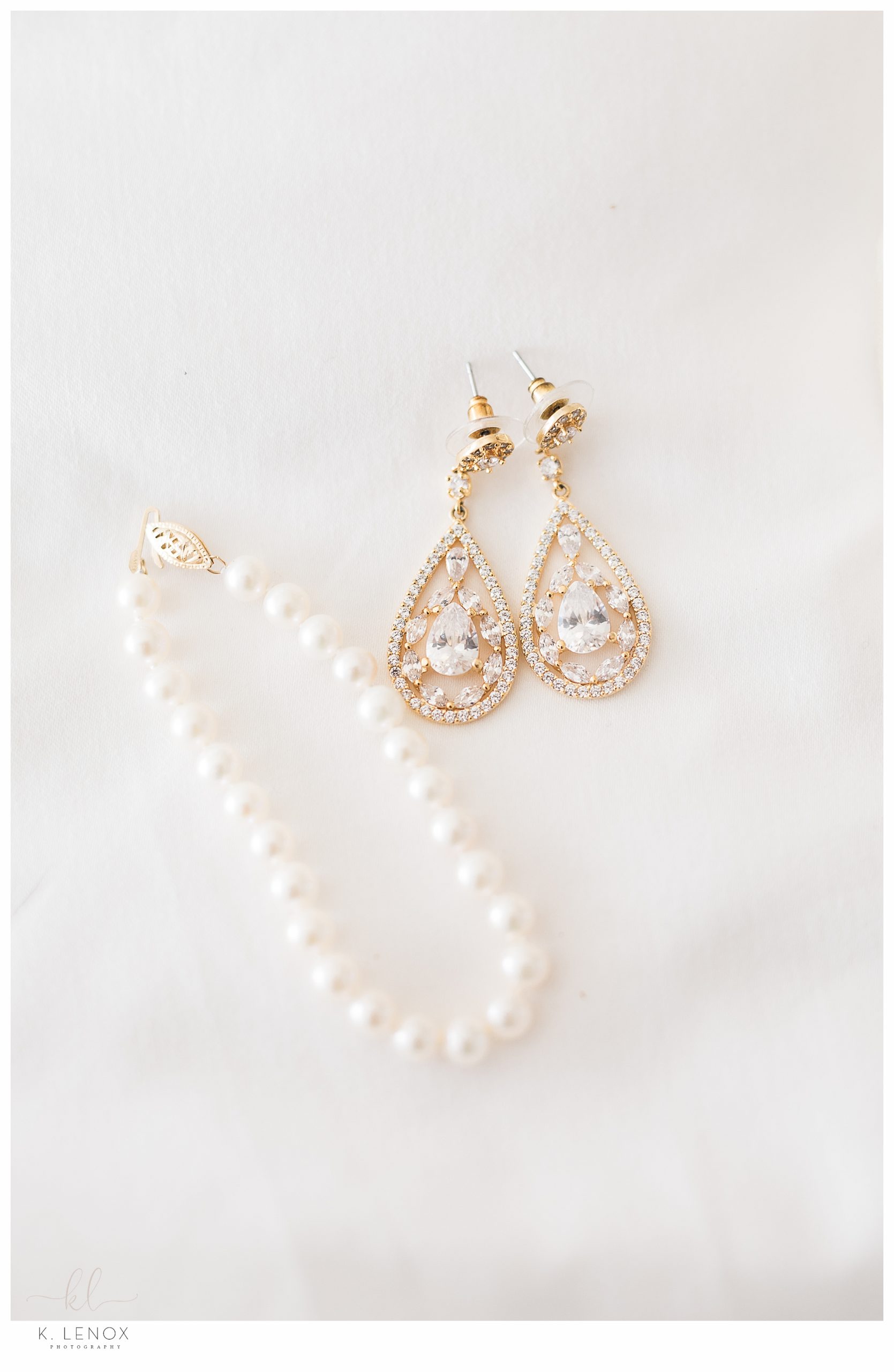 White Pearl necklace and diamond tear drop shaped gold earrings. 