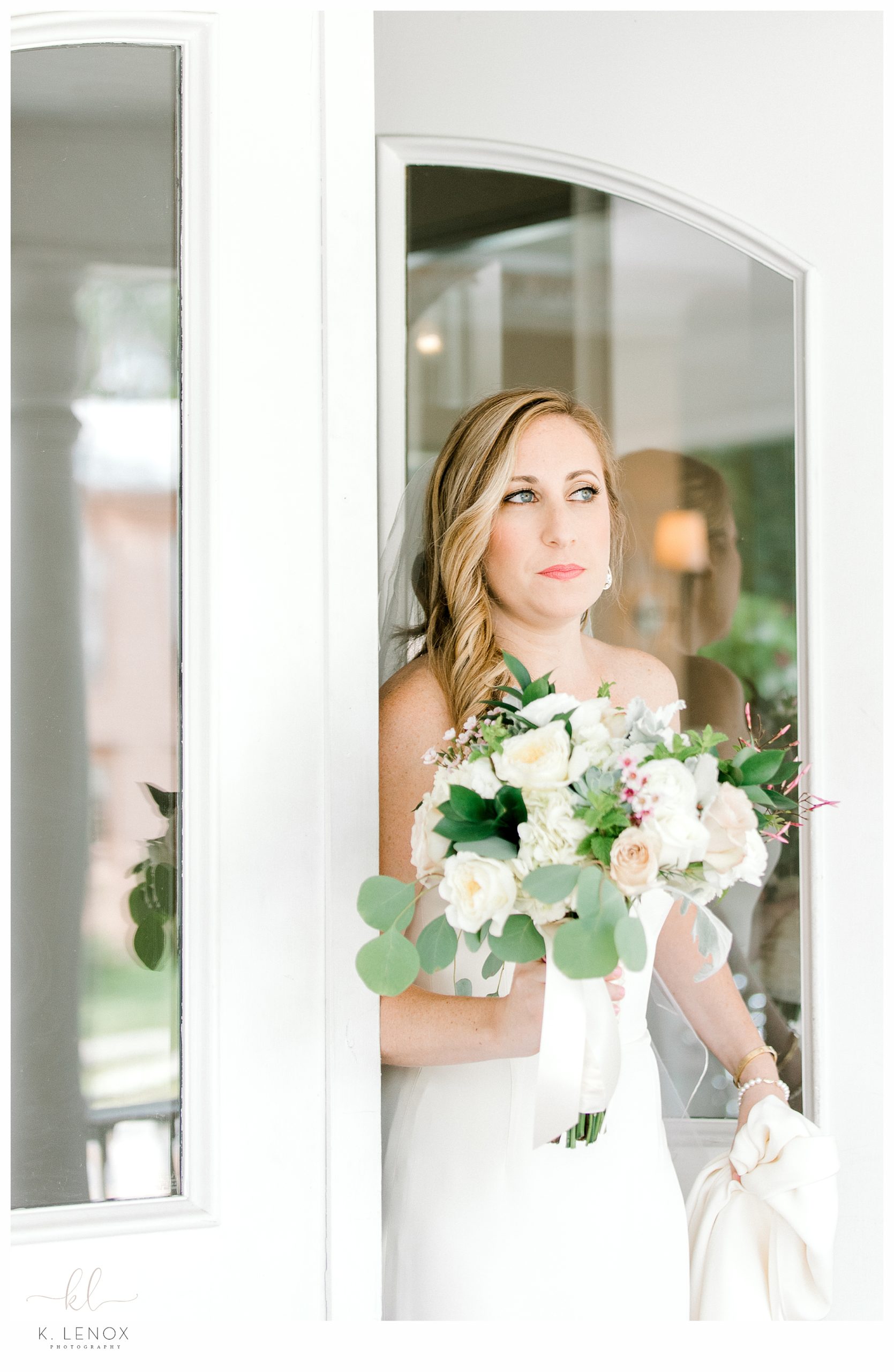 Photo of a bride coming out of the doors of the Charles Orvis Inn at the Equinox Resort. 