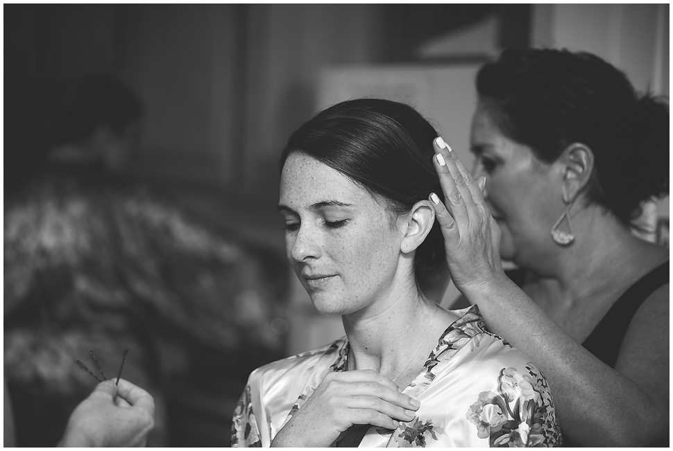 Black and white photo of a bride getting her hair done by Exodus Salon. 