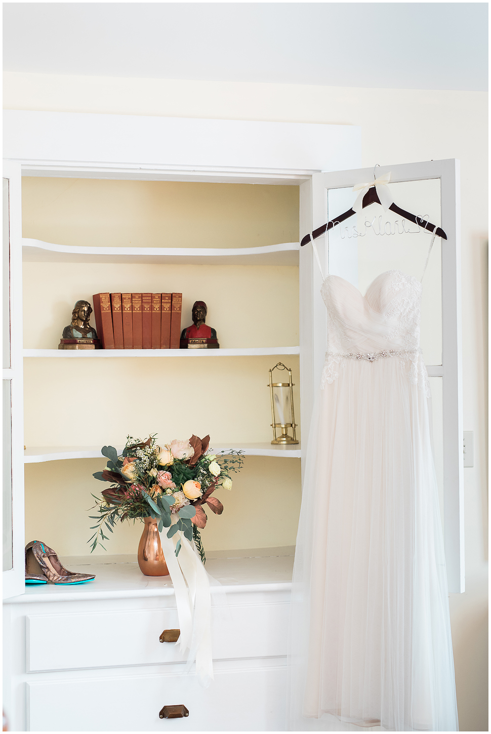  Wedding dress and bridal bouquet in front of a custom built in shelf at Alyson's Orchard. 