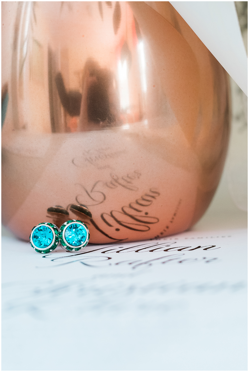 Teal jeweled earrings photographed in front of a copper vase on a wedding day at Alyson's Orchard. 