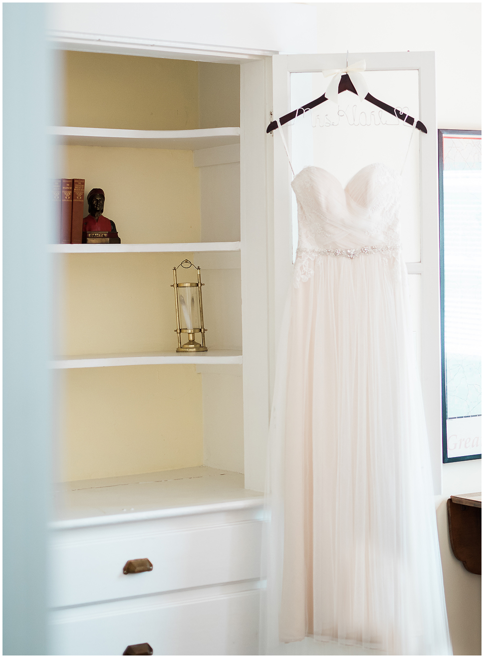 Simple White wedding dress hanging on customized hanger at Alyson's Orchard. 