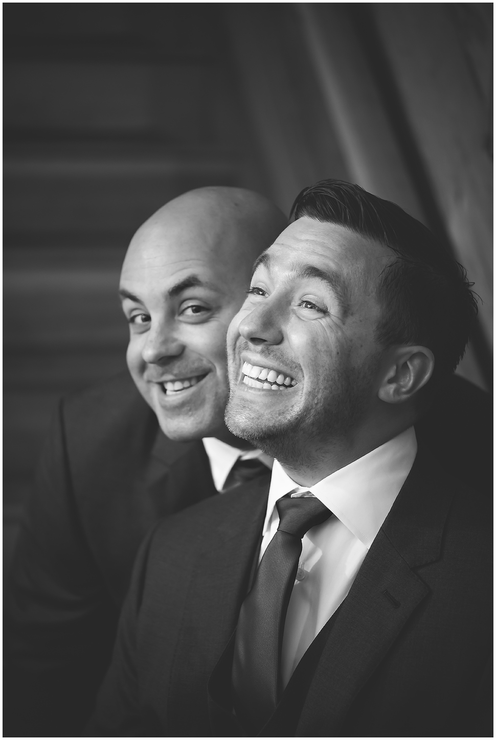 Black and White photo of a groom and his best man smiling silly. 