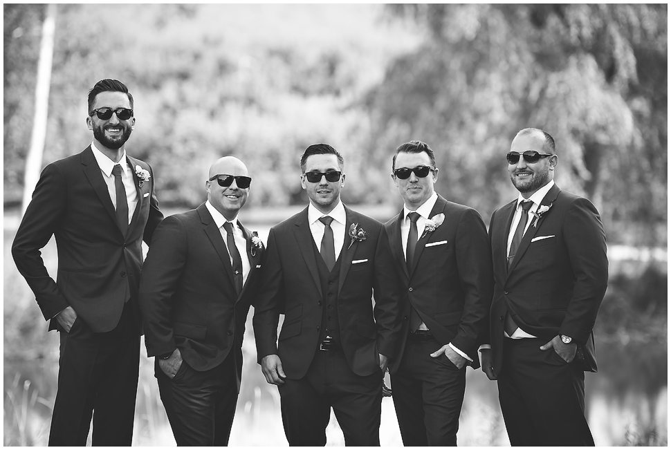 Black and white Formal Groomsmen portrait with 5 guys wearing tuxes and sunglasses. Alyson's Orchard. 