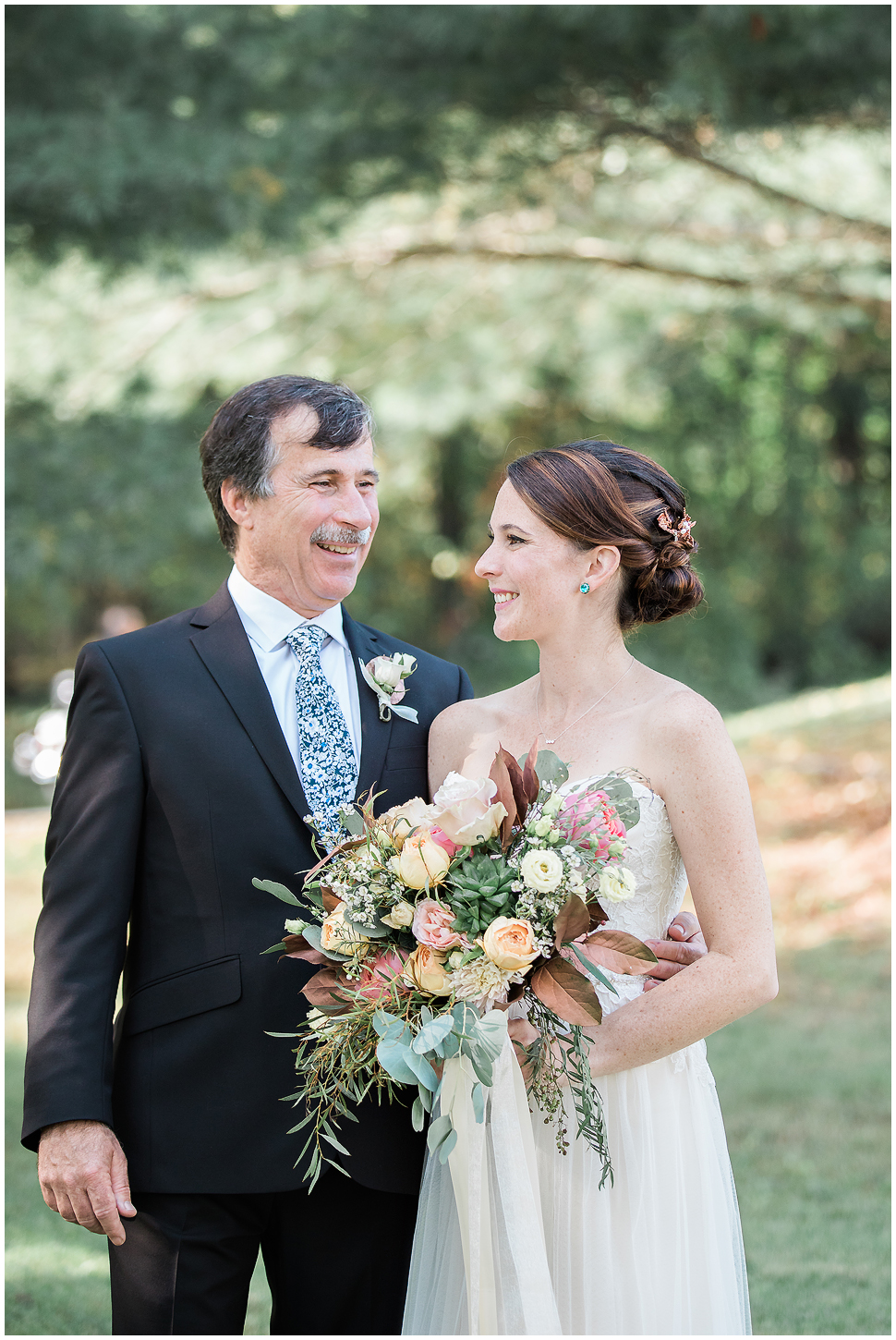 Candid portrait of a bride holding floral bouquet w/ copper leaves and her Dad. 
