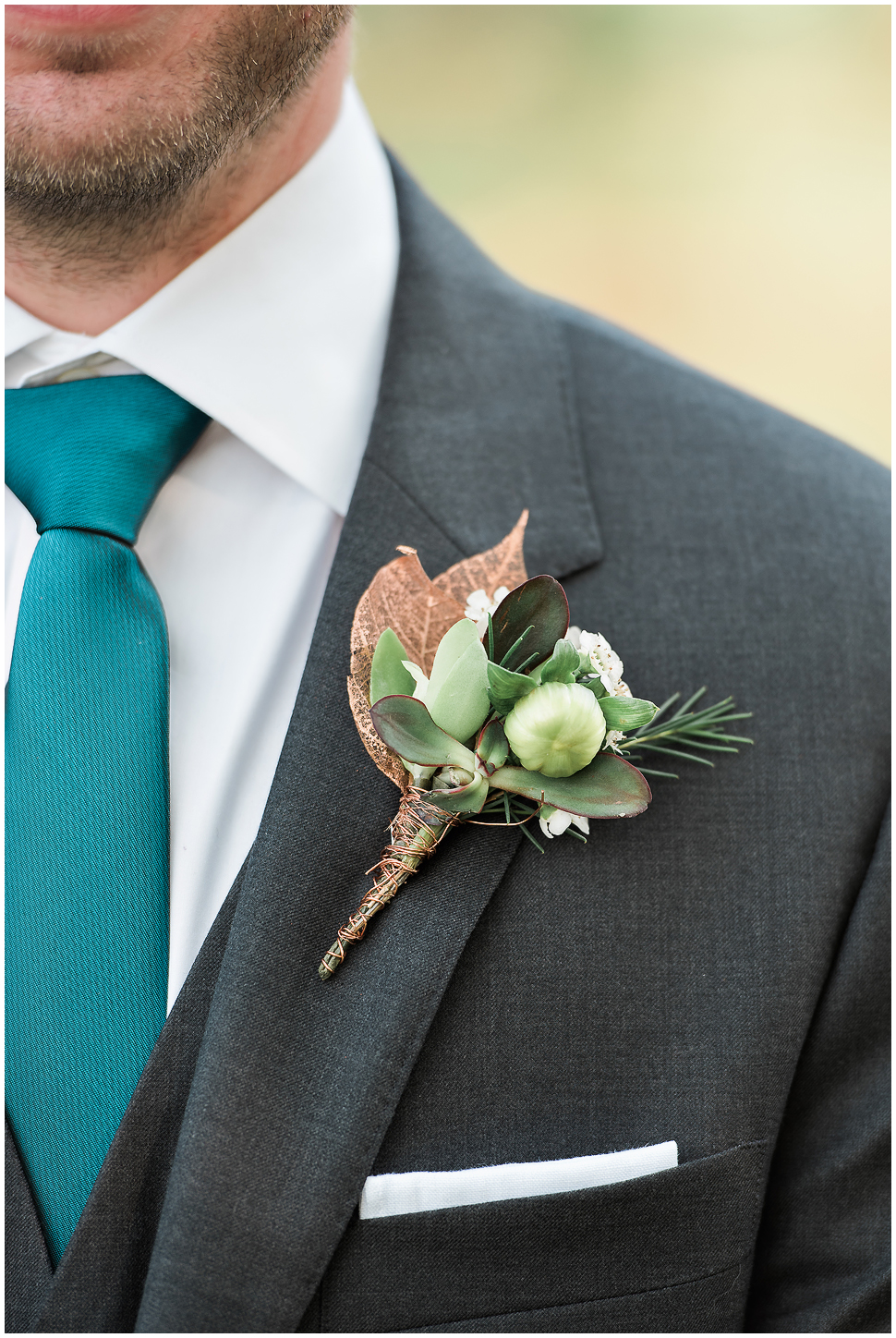 Close up of Grooms Boutonnière showing succulents, copper wire and copper leaf. Made by Naturally Elegant designs. 