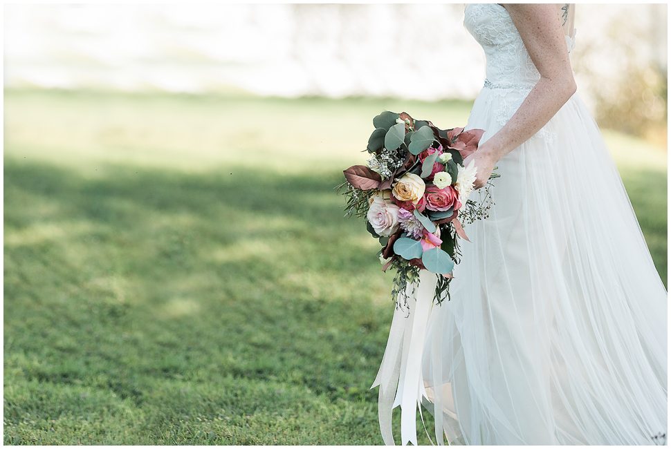 Bride walking holding floral bouquet. 
