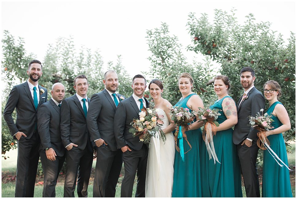 Wedding party formal portrait showing teal bridesmaids dresses and guys with teal ties. 