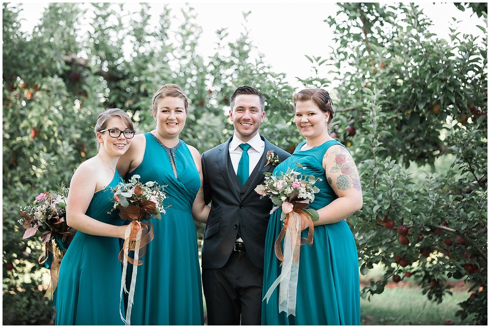 Groom with Bridesmaids wearing teal dresses. 
