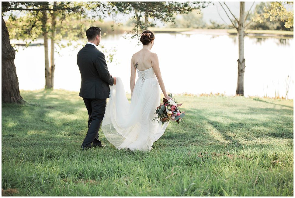 K. Lenox Photography captured a bride and groom walking near the pond at Alyson's Orchard. 