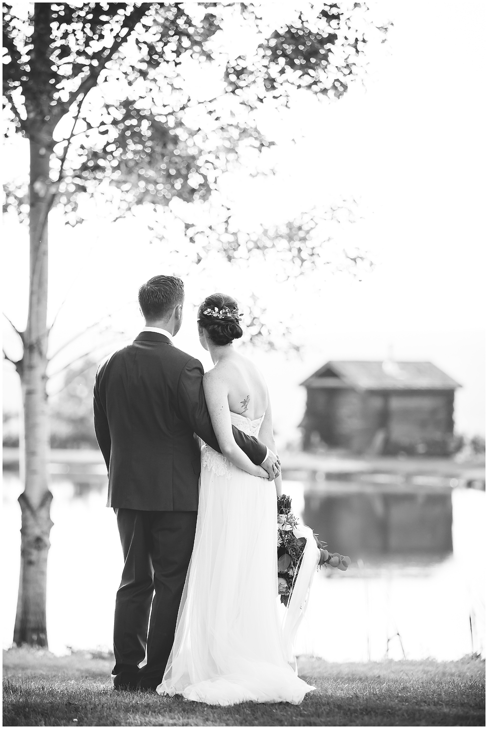 K. lenox photography captured this black and white photo of a bride and groom looking at the pond at Alyson's Orchard. 