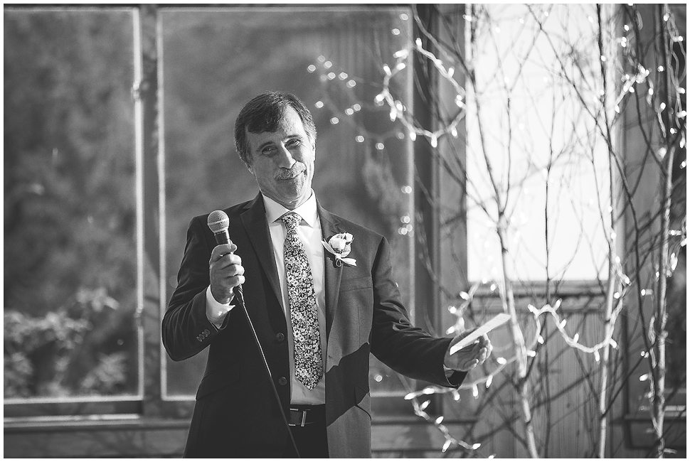 Black and white photo of dad giving speech at wedding reception. 
