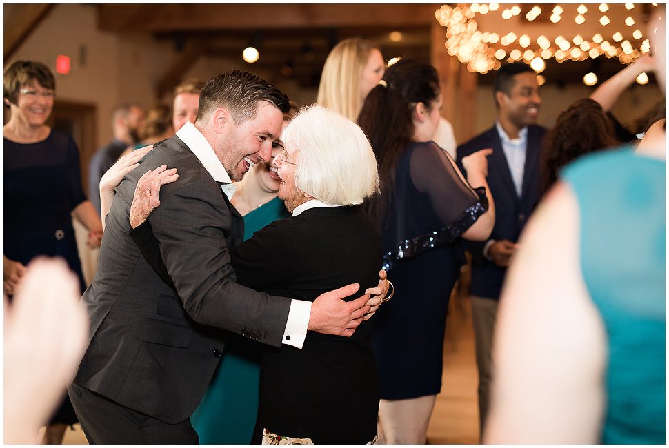 Groom hugs his grandmother at his wedding reception. 