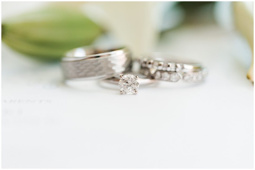 Photo shows a set of wedding rings. White gold textured mans ring- female diamond rings and a solitaire diamond ring. 
