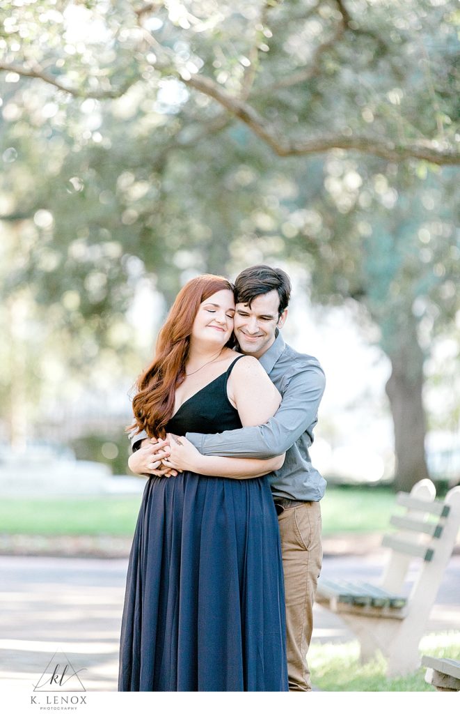 Man hugs his fiance during their Charleston SC engagement session with K. Lenox Photography