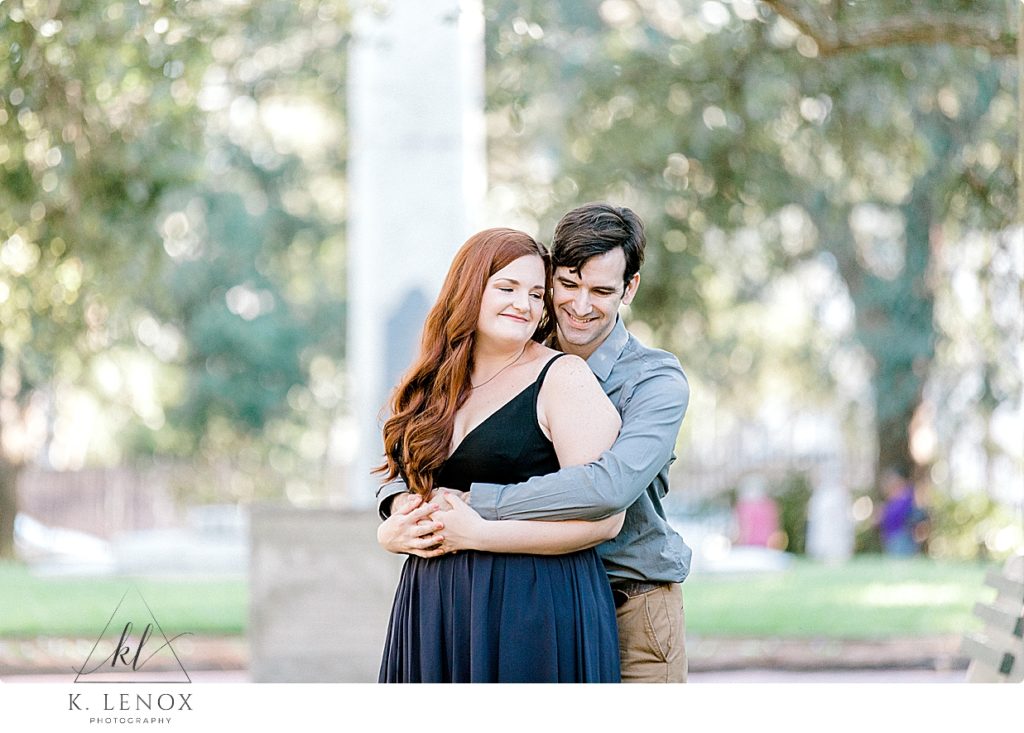 Man hugs his fiance during their light and airy Charleston Engagement session with K. Lenox Photography