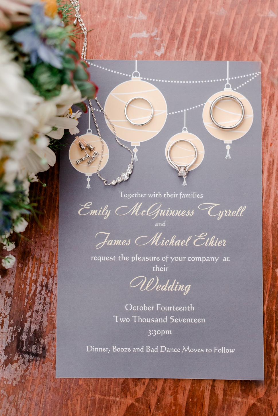 contemporary styled wedding invite in grey and pale yellow shown next to wildflower bouquet