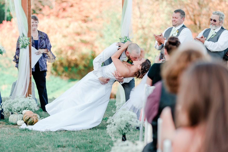 groom sweeps bride off her feet for a kiss during their wedding ceremony at their Grand View Inn Resort Wedding 