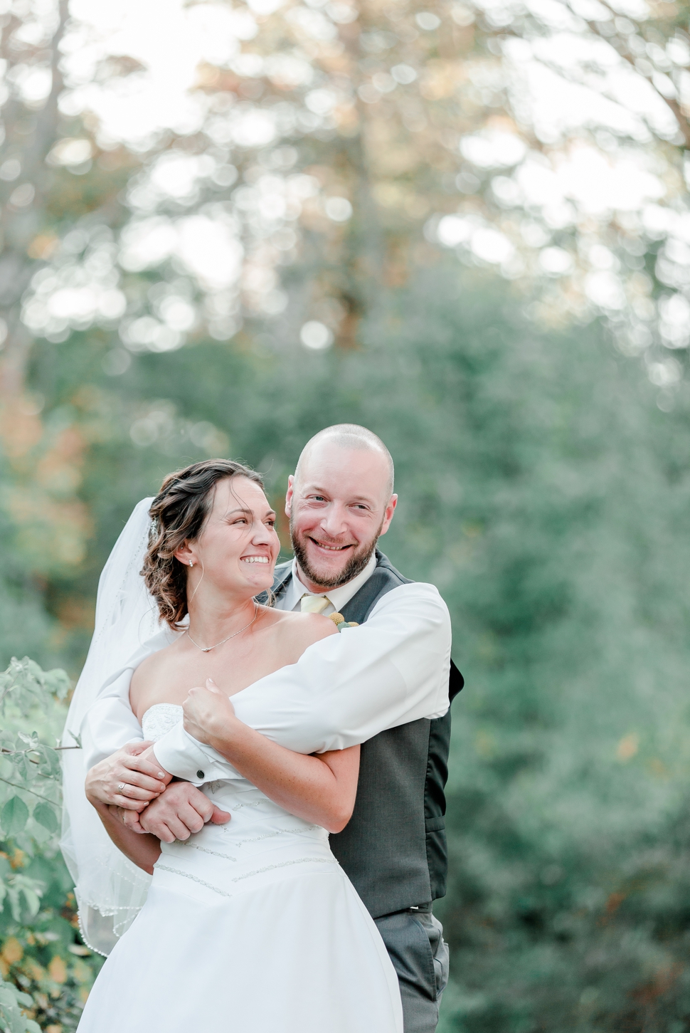 natural portrait of bride and groom laughing together during their fall wedding