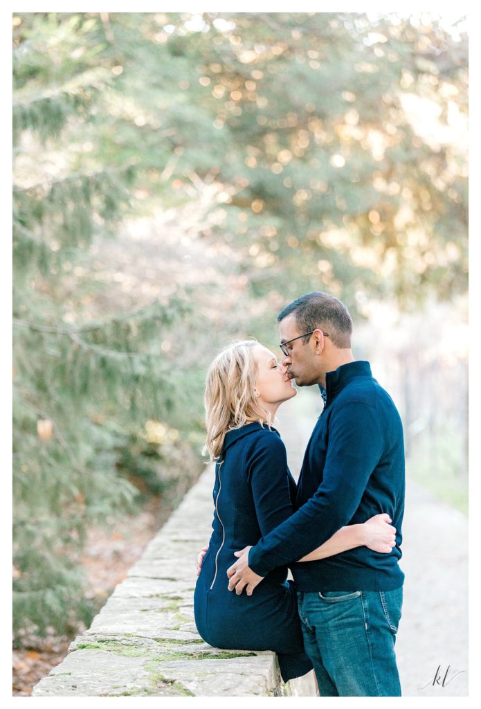 Man and woman share a gentle kiss during their engagement session at the Arboretum in Boston