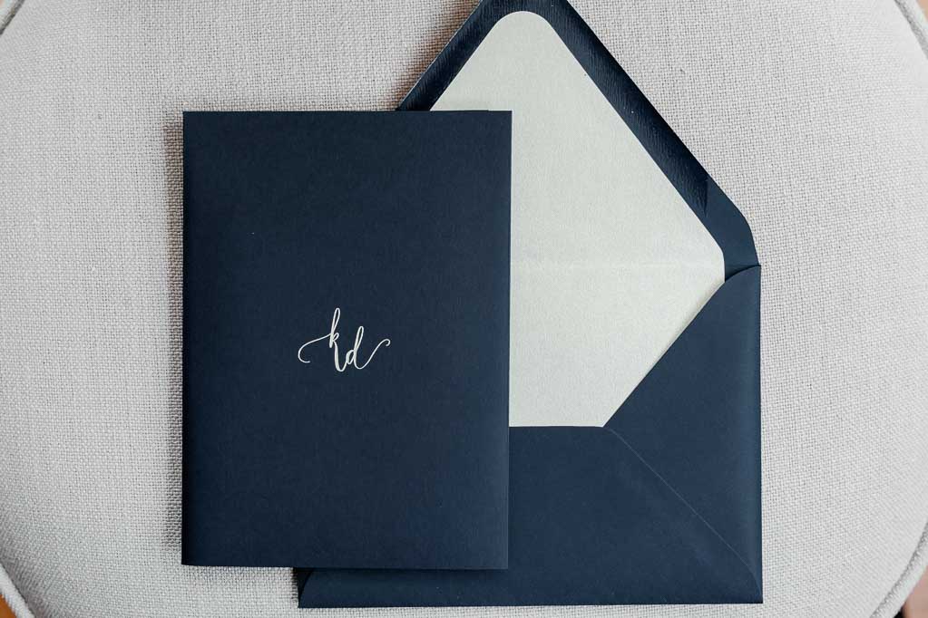 Deep Navy Blue invitation with custom calligraphy debossed on front. 