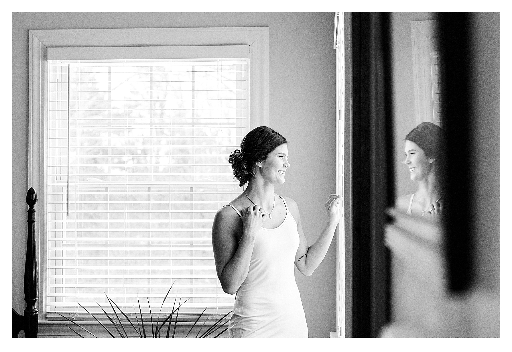 Black and White photo of a woman looking out the window while preparing for her wedding at Aldworth Manor