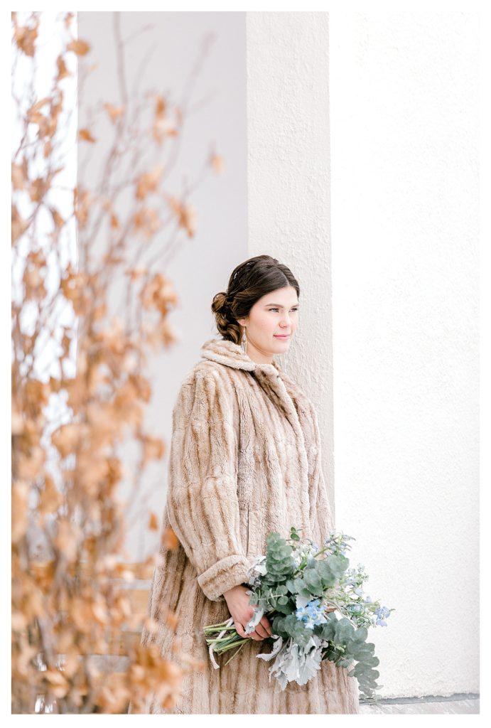 Aldworth Manor Winter Wedding- picture showing a bride wearing a fur coat and holding a bouquet