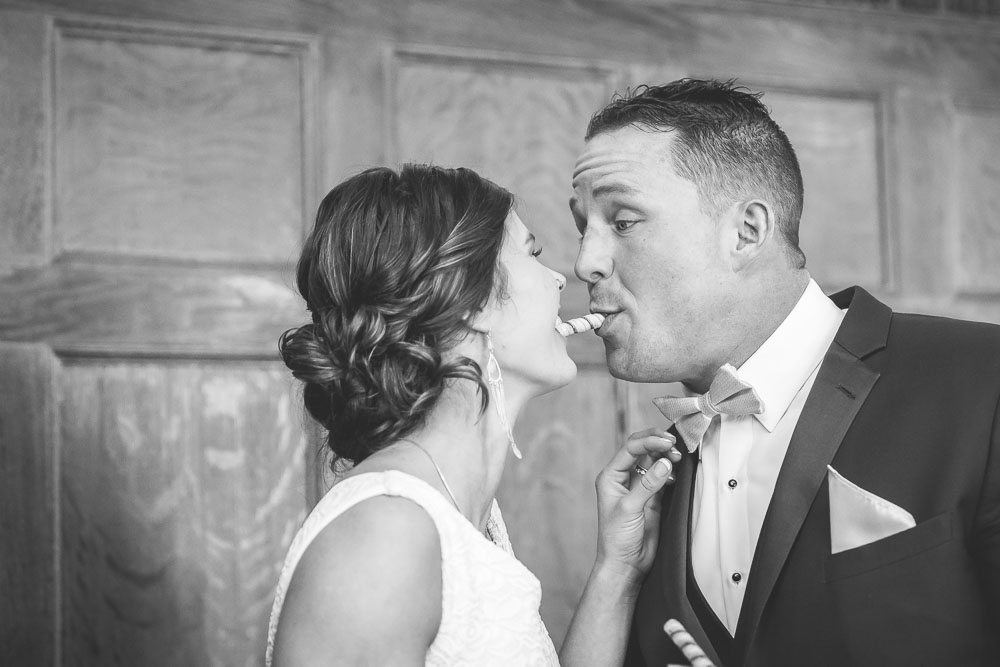 Black and White Candid photo of bride and groom sharing a snack at the Aldworth Manor in Harrisville NH.