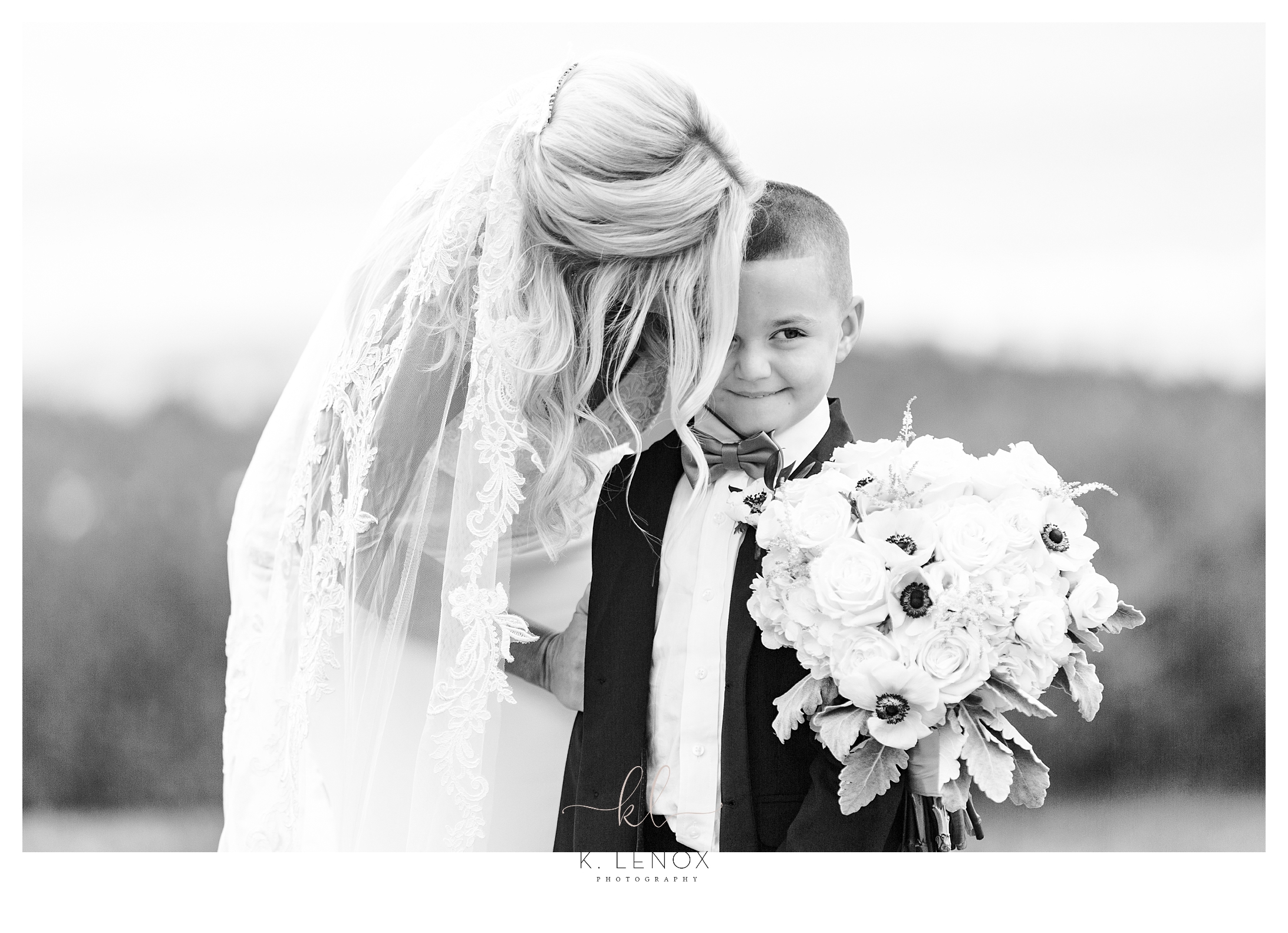 Black and White Candid photo showing a bride talking to the Ringbearer. 