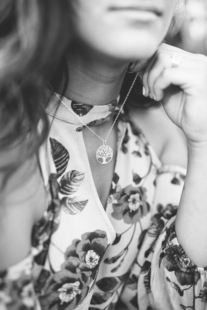 Black and White detail photo of a family tree necklace being worn by a high school senior girl during her portrait session