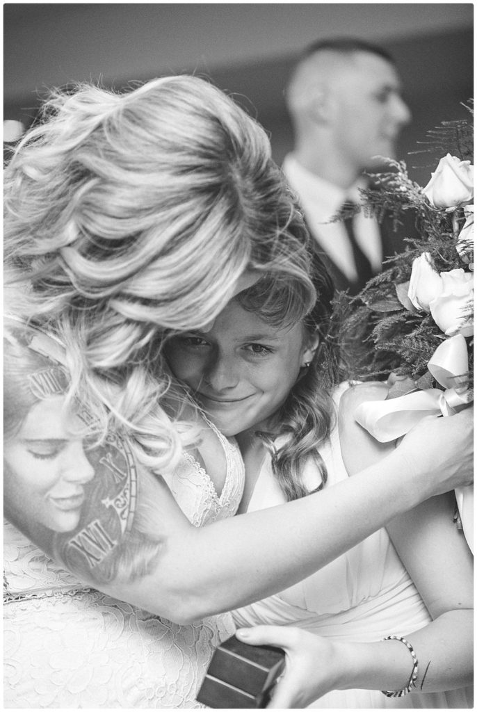 Wedding at Riverside Hotel NH. Black and white photo of sisters hugging. 