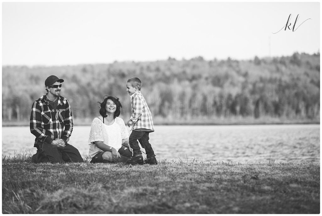 Black and white candid family photo that shows an authentic moment between a mom, dad and 5 year old son. 