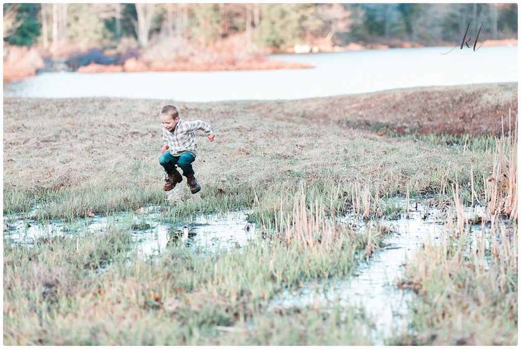 Little boy jumping in the mud during some fun family photos in the Monadnock Region of NH.