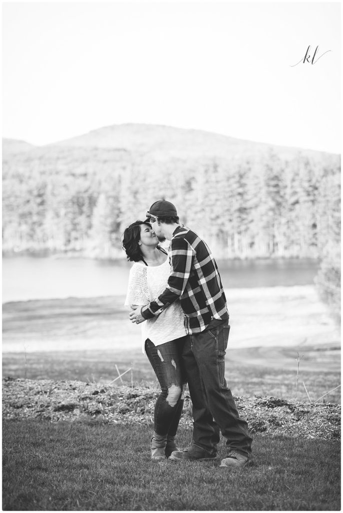 Black and White photo of a couple snuggling in front of Mount Monadnock in Rindge NH. 