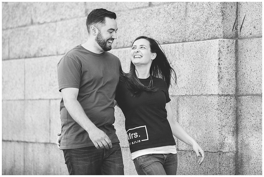 Black and White Natural and Unposed Engagement photo of man and woman walking and laughing. 