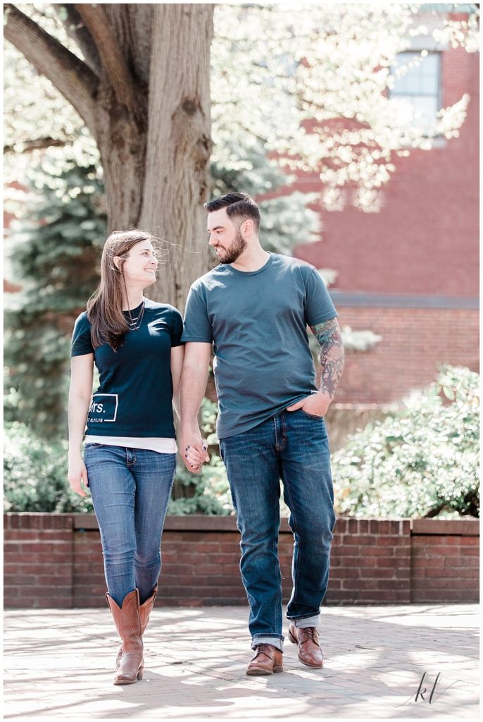 Unposed and Natural Engagement Photo showing man and woman holding hands and walking. 
