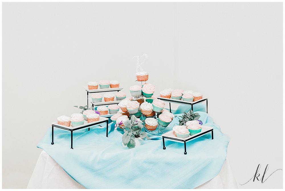 Cupcake display with teal table cloth. 