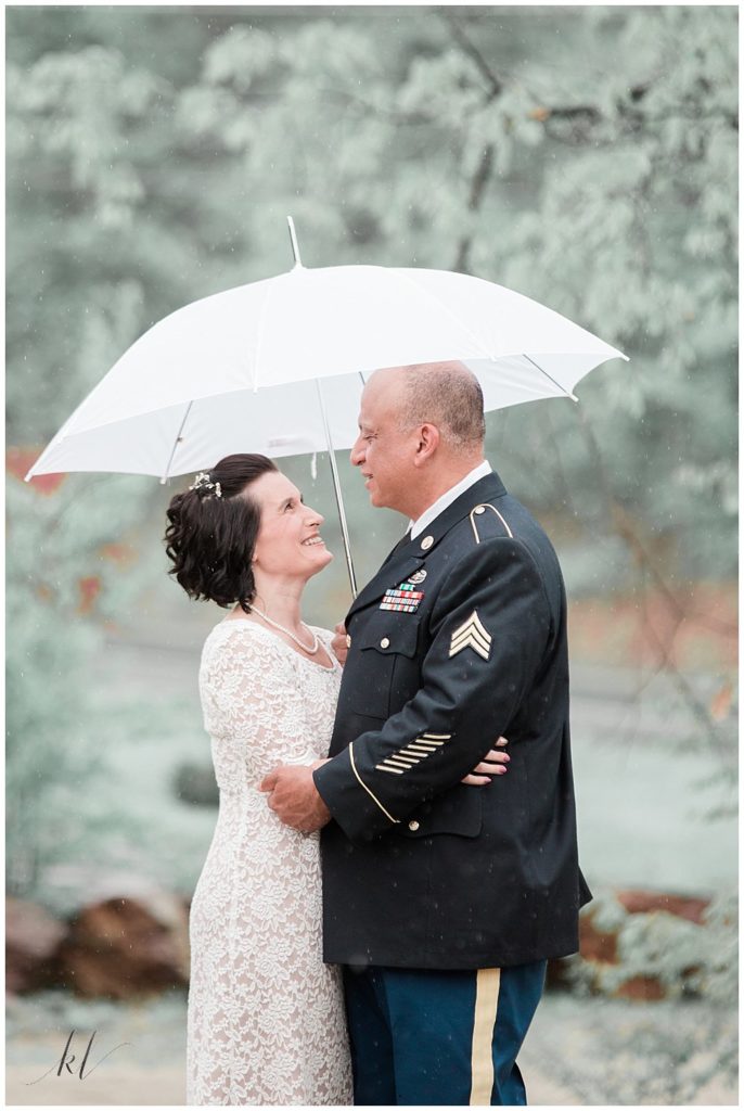 Portrait of husband in dress blues and wife on a rainy day for their Vow Renewal Celebration