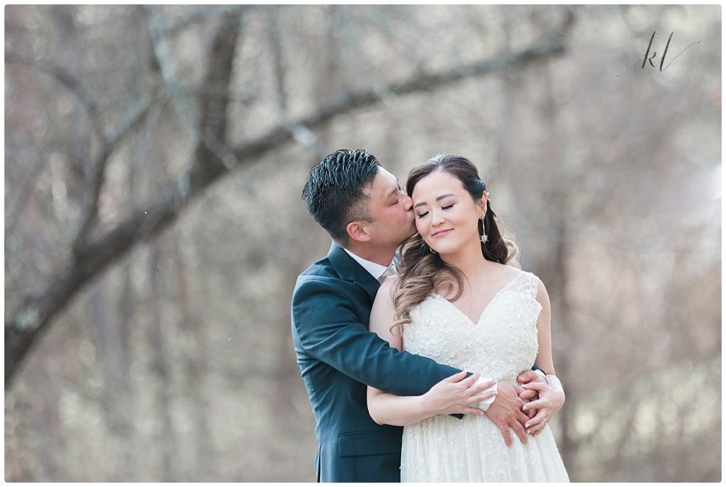 Groom gives his bride a sweet kiss on the cheek during an authentic and natural wedding day portraits. 