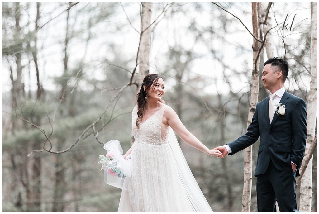 Bride and groom share an authentic moment while walking hand in hand after their simple back yard wedding. 
