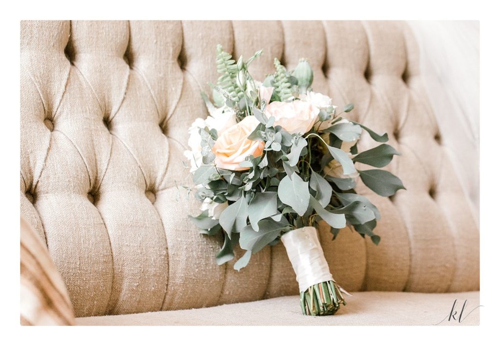 Floral wedding bouquet with peach and white roses and greenery.  Light and Airy photo taken by K. Lenox at the Bedford Village inn. 