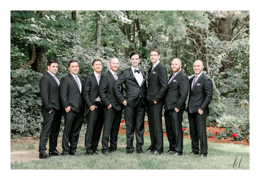 Groom and his 7 groomsmen posing for a formal portrait at the Bedford Village Inn summer wedding. 