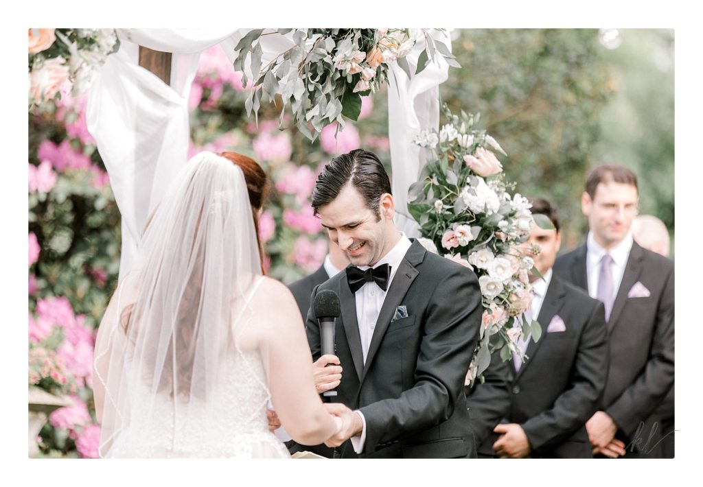 Groom wearing tuxedo reads his vows during a summer wedding at the Bedford Village inn. 