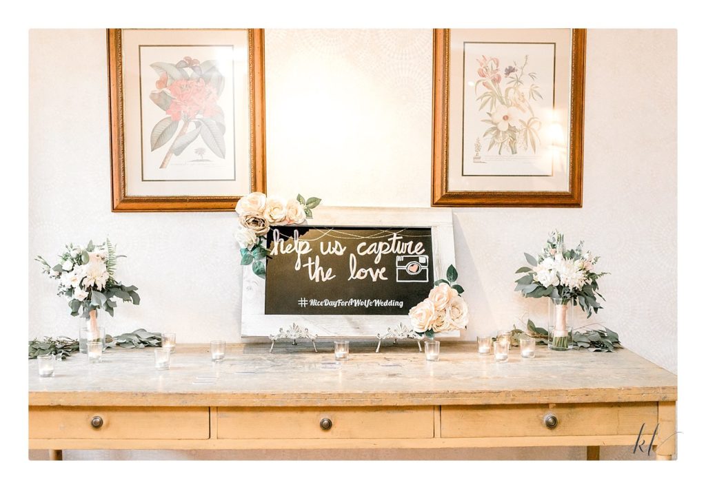 Bedford Village Inn summer wedding entrance table with seating placements.  Chalkboard with hashtag