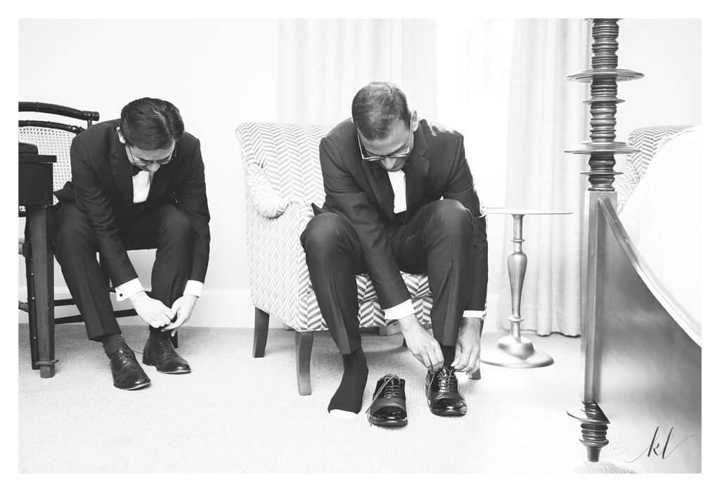Black and White Photos of a Groom and his best man putting on their shoes. 